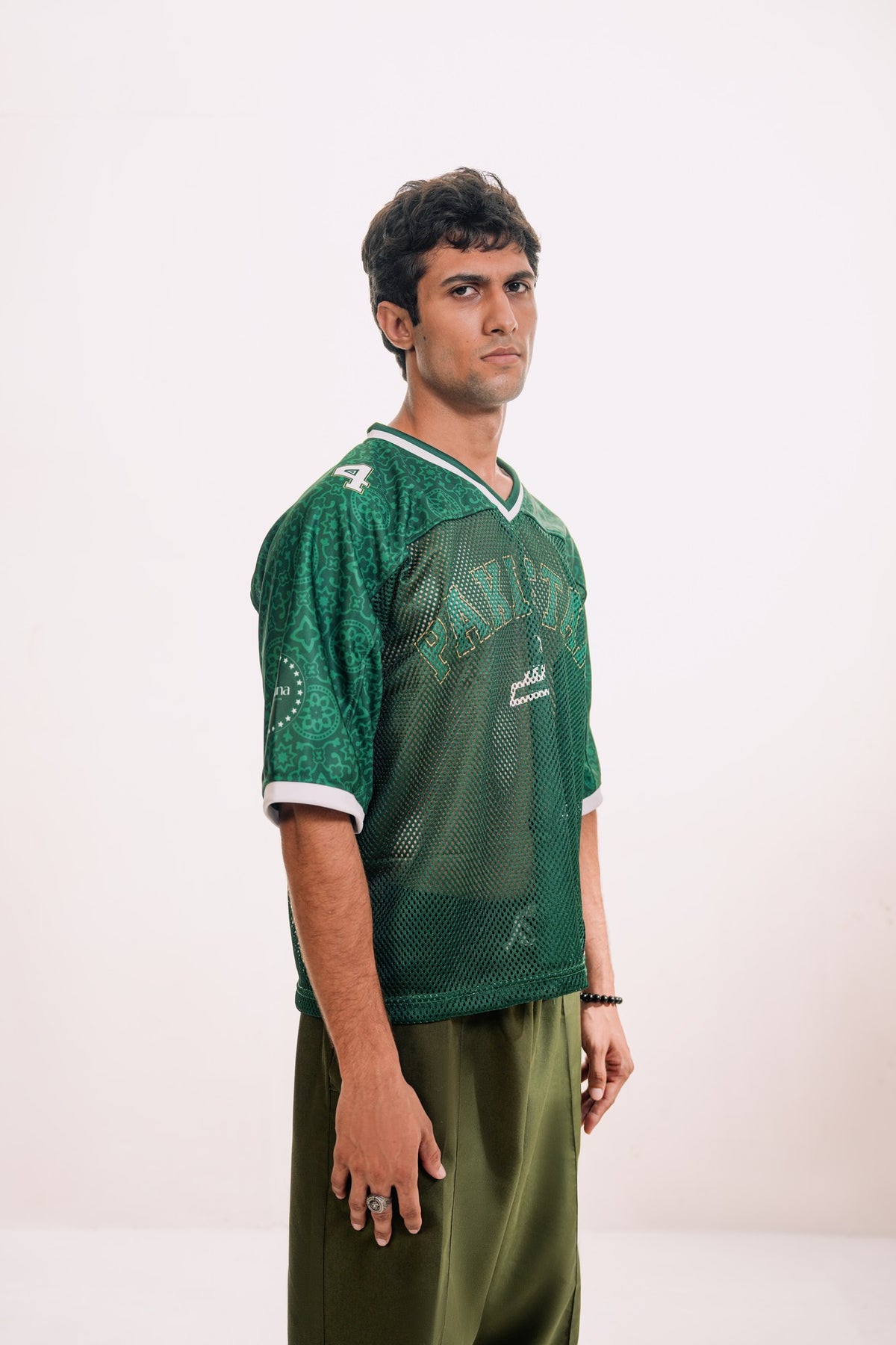 model:male model:studio | Green Passport jersey — three-quarter view showing drape, studio